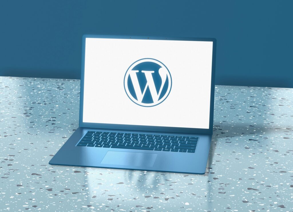 Computer with the WordPress logo on it by Deng Xiang on Unsplash: https://unsplash.com/photos/a-laptop-computer-sitting-on-top-of-a-table-YBtAJPcvc4Y