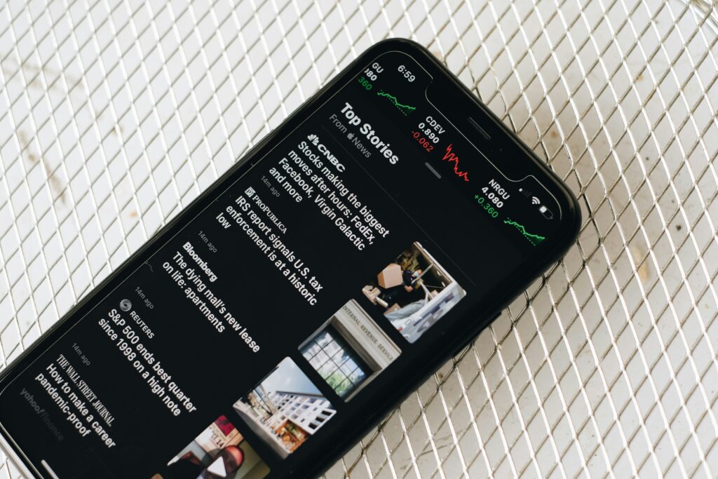 Black phone looking at news articles by Fujiphilm on Unsplash: https://unsplash.com/photos/black-samsung-android-smartphone-on-white-textile-VgU5zIEy57A