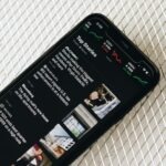 Black phone looking at news articles by Fujiphilm on Unsplash: https://unsplash.com/photos/black-samsung-android-smartphone-on-white-textile-VgU5zIEy57A
