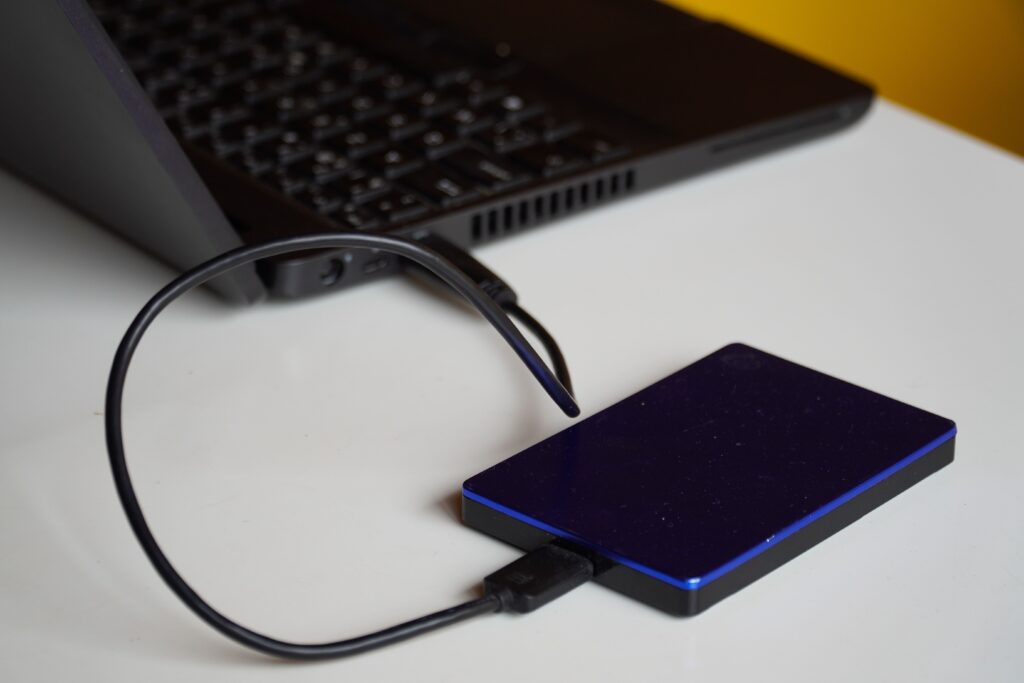Photo of a external hard drive plugged into a laptop by Budget Bizar on Pexels: https://www.pexels.com/photo/portable-laptop-power-bank-15882042/