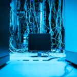 Computer plugged into servers in a blue room by Panumas Nikhomkhai on Pexels: https://www.pexels.com/photo/monitor-and-wires-behind-17489155/