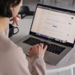 Woman scrolling on her computer from: https://www.pexels.com/photo/crop-unrecognizable-businesswoman-typing-on-laptop-at-home-4050216/