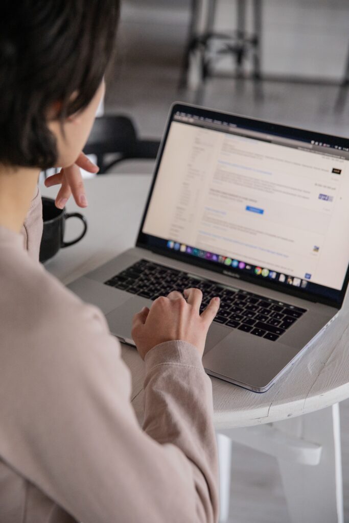 Woman scrolling on her computer from: https://www.pexels.com/photo/crop-unrecognizable-businesswoman-typing-on-laptop-at-home-4050216/