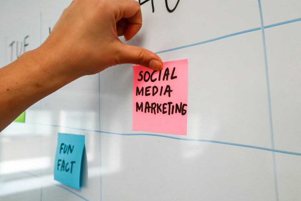 White board with a sticky note reading social media marketing by Walls.io on Unsplash: https://unsplash.com/photos/a-hand-is-writing-on-a-sticky-note-9r6EztKam9M